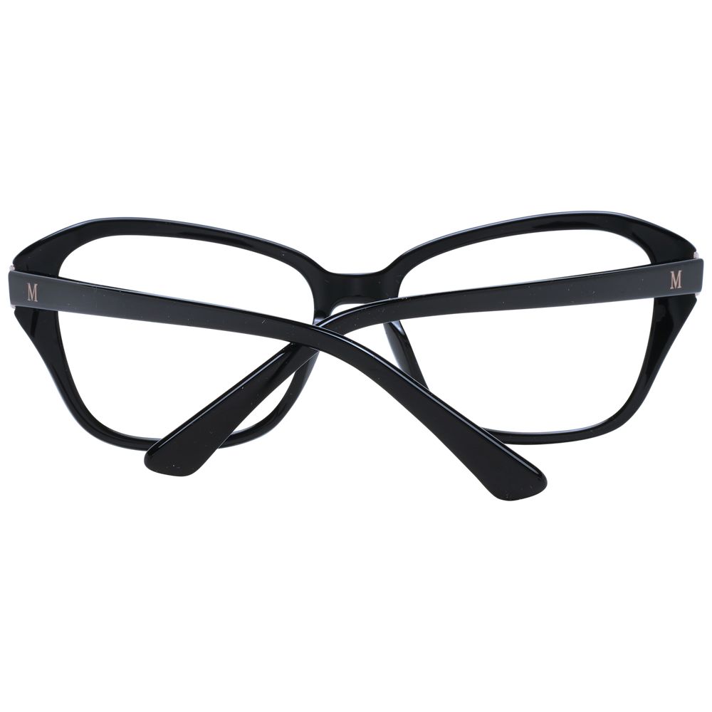 A pair of Marciano by Guess black plastic glasses (frames) for women with thick rectangle frames is shown, temples crossed in front of the lenses, and the letter M visible on the outer side of both temples.
