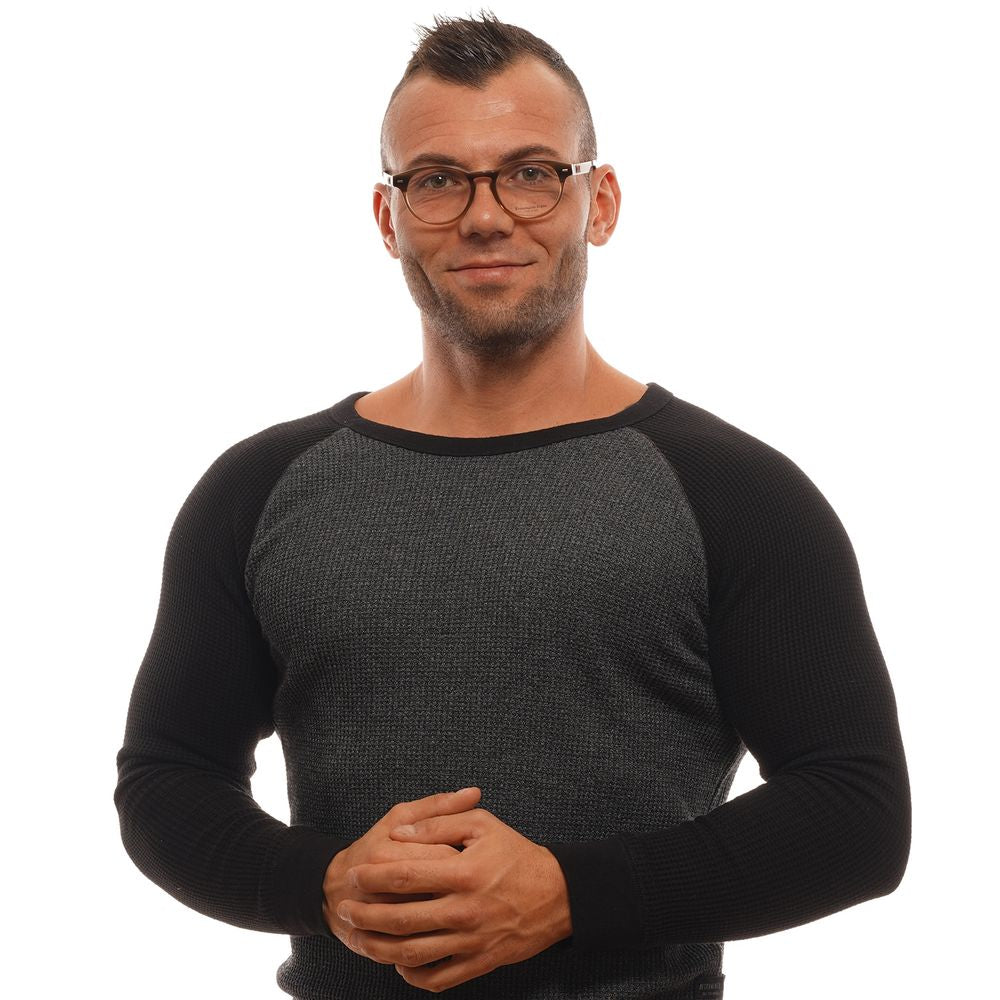 A man with short hair wears Ermenegildo Zegna Brown Plastic Glasses, featuring a full-rim frame, and a dark long-sleeved sweater. He stands against a white background, smiling slightly with his hands clasped in front of him.