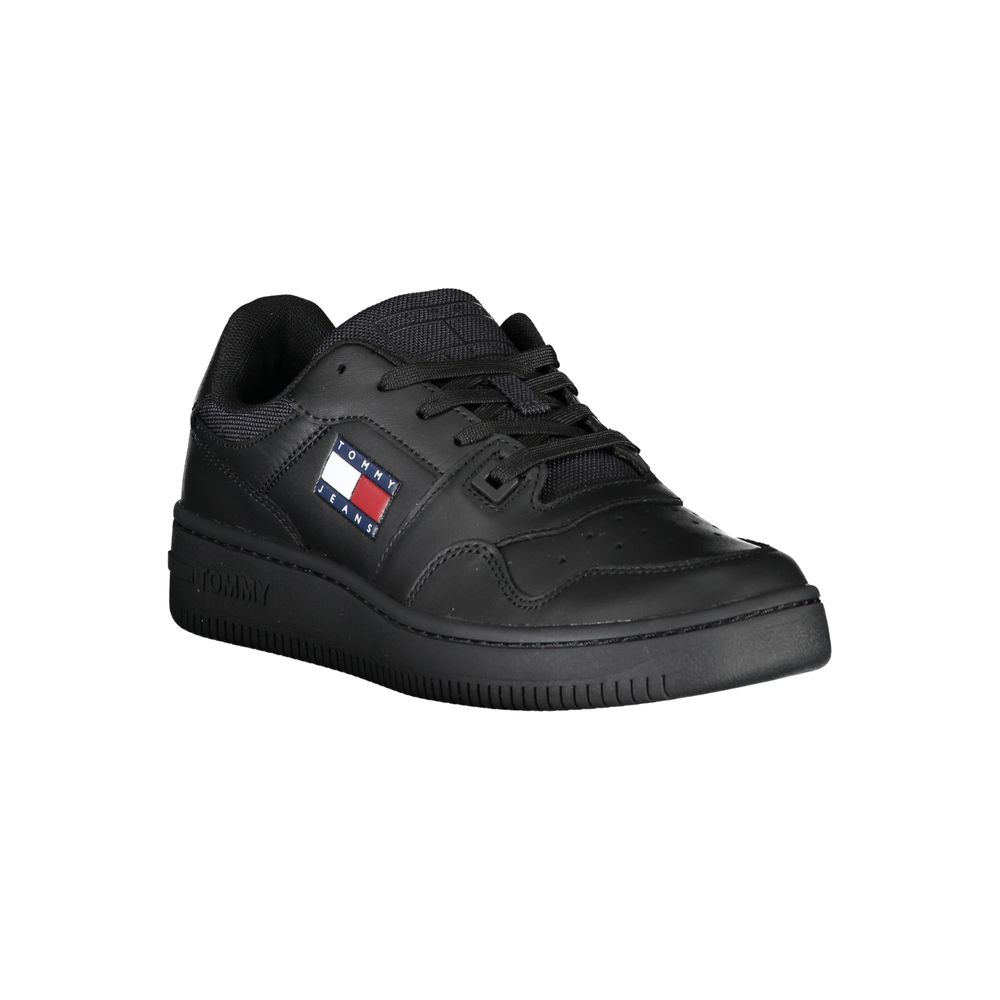 The Tommy Hilfiger Black Leather Women Sneaker features laces, a padded collar, textured sole, and the iconic red, white, and blue logo on the side, shown against a plain white background.